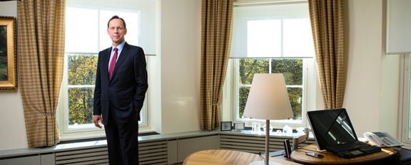 Sampo Group CEO Kari Stadigh standing in an office with two large windows in the background.