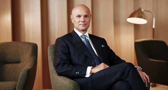 Sampo Group CEO Morten Thorsrud sits in an armchair, with warm lighting and wooden elements in the background.