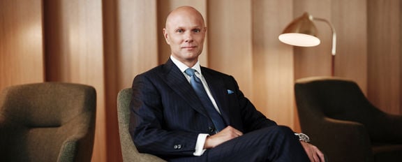 Sampo Group CEO Morten Thorsrud sits in an armchair, with warm lighting and wooden elements in the background.
